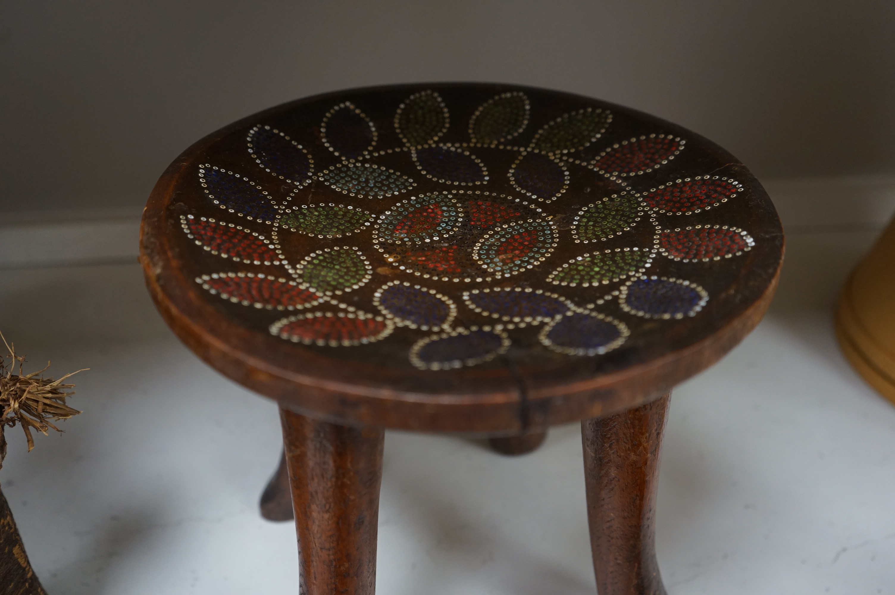 A group of African tribal artefacts, including a stool, a large painted carved mask, a carved gourd container and three carved figures, mask 76cm high. Condition- fair to good